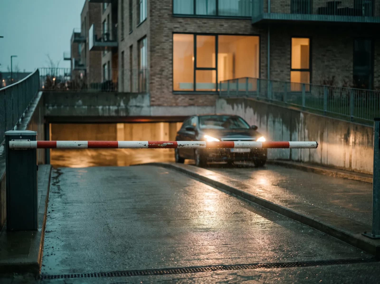 A car-park barrier at a residential building, with a car waiting